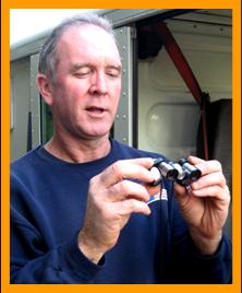 Mailman examining miniature binoculars.
Hombre con binoculares en miniatura.
Homme avec des jumelles miniatures.
Mann mit miniatur fernglas.