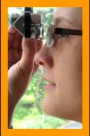 Woman looking through miniature binoculars