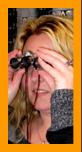 Woman looking through small binoculars