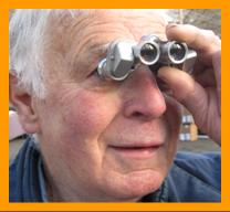 Man looking through mini binoculars.
Mann beobachtel mit einem fernglas.
Homme observan avec des jumelles.
Hombre observando con binoculares.