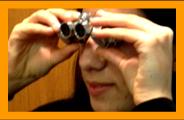 Young Woman looking through miniature  binoculars