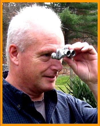 Man looking through miniature binoculars