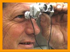 Man looking through micro binoculars