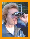 Woman looking through miniature binoculars