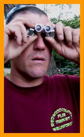 Man looking through miniature binoculars