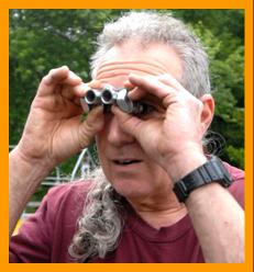Man looking at birds with miniature binoculars