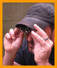 Man looking through miniature binoculars
