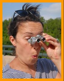 Wild haired woman amazed by view through binoculars