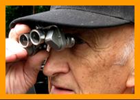 Senior with miniature binoculars. www.miniaturebinoculars.com.