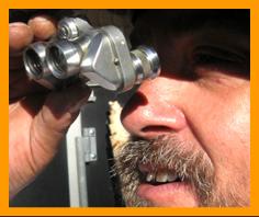 man looking through binoculars. www.miniaturebinoculars.com