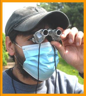 Man with mask observing the game through binoculars.
Mann schaut durch ein furnglas.
Homme observant avec des jumelles.
Hombre observando con binoculares.
Man observerar med kikare.
L'uomo osserva con il binocolo.