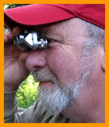 Amused man with miniature binoculars. www.miniaturebinoculars.com