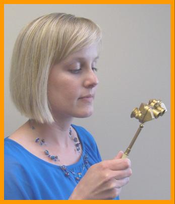 Blonde Woman Examining Gold Miniature Binoculars