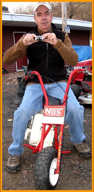 Man on miniature motorcycle with miniature binoculars