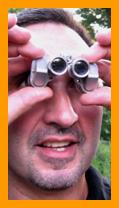 amused man using Miniature Binoculars