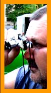 Man Looking Through Miniature Binoculars