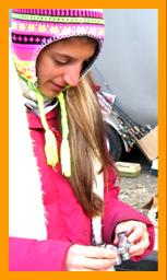 Woman Examining Miniature Binoculars in the cold