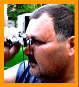 Man Looking Through Miniature Binoculars