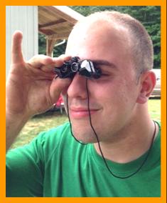 Young Man looking with Miniature Binoculars