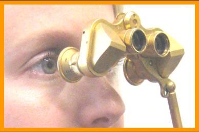 Woman looking through gold Fata Mogana Binoculars