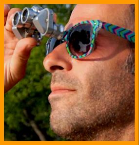 Man in Colorful Sunglases Looking Through Binoculars