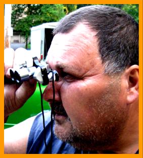 Man Looking Through Miniature Binoculars