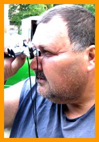 Man Looking Through Miniature Binoculars