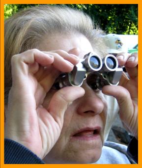 Old Woman looking through miniature  Binoculars.
Frau schaut durch ein miniatur fernglas.
Femme regardant a travers de jumelles miniature.
Mujer mirando a traves de binoculares en miniatura prismatoicos.
Donna che guarda attaraverso il binocolo in miniatura.
