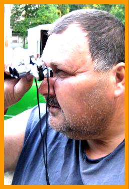 Man Looking Through Miniature Binoculars