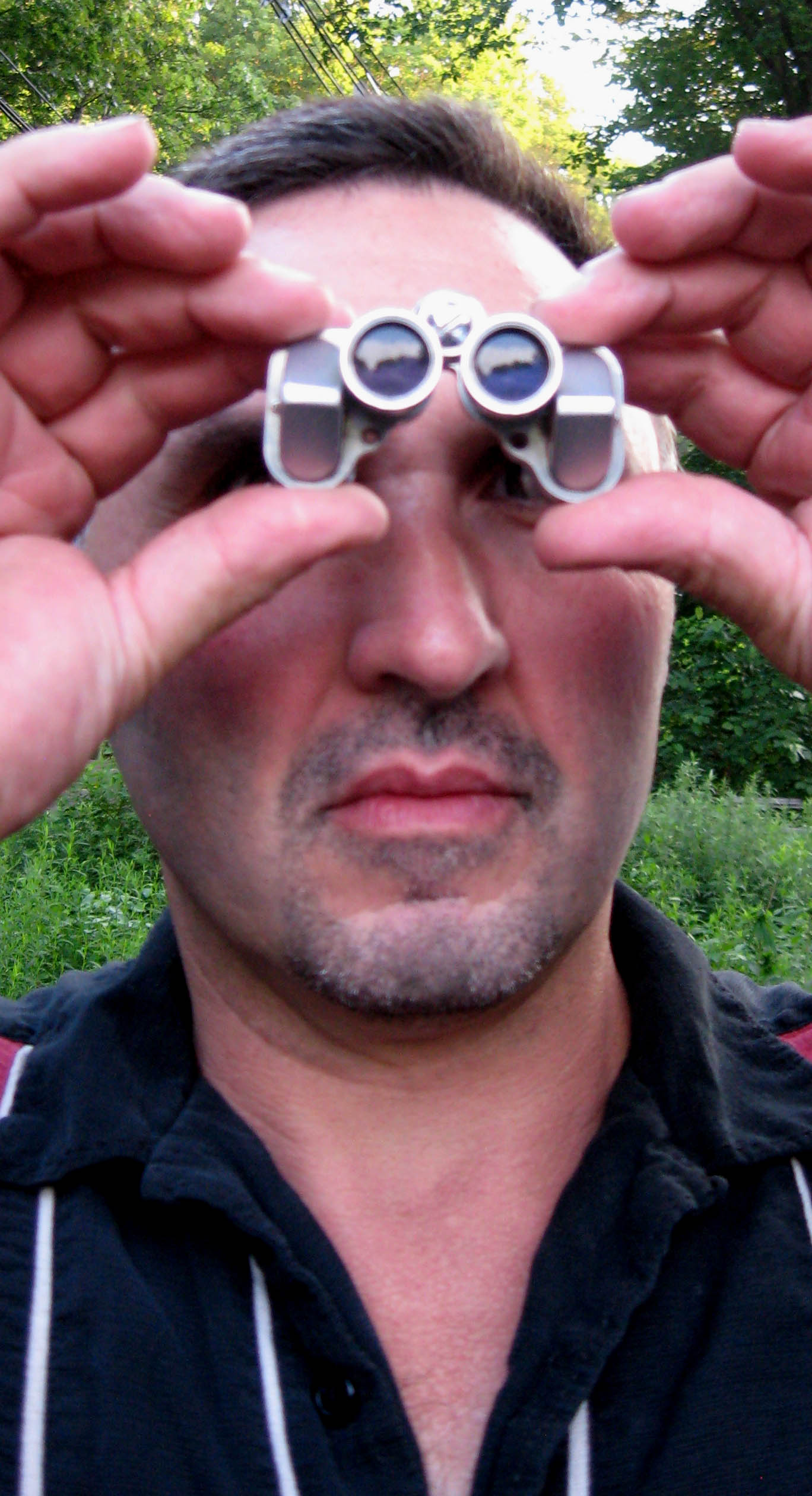 Man Viewing With Tiny Binoculars