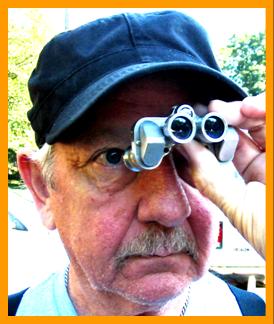 Man Looking Through Miniature Binoculars